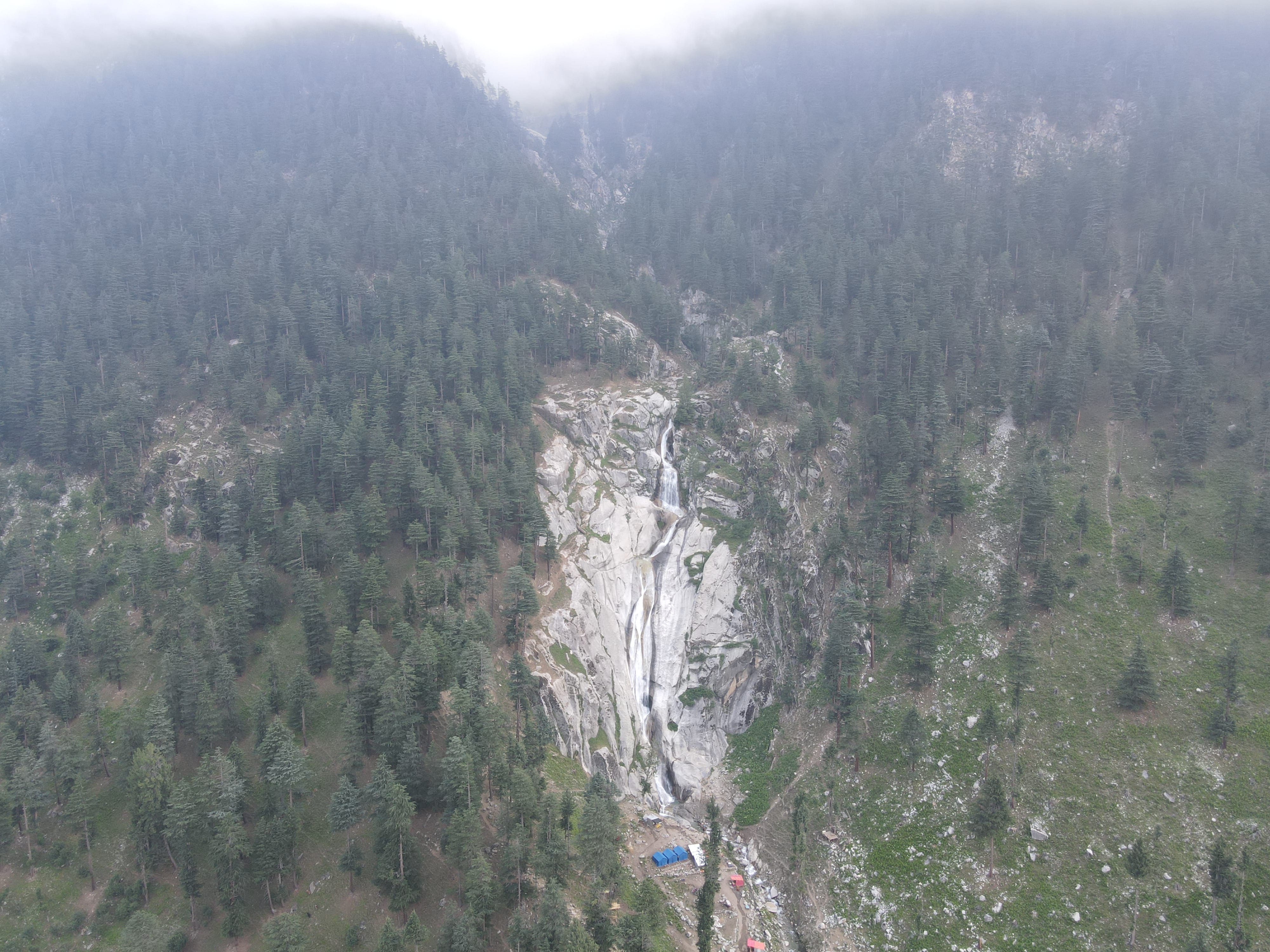 Dramatic mountain waterfall in misty forest
